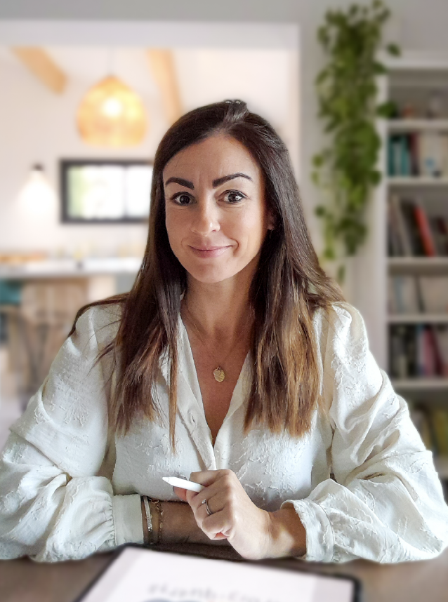 Marie Saquet-Gouville graphiste et illustratrice indépendante un stylet à la main devant son ipad pro et souriante
