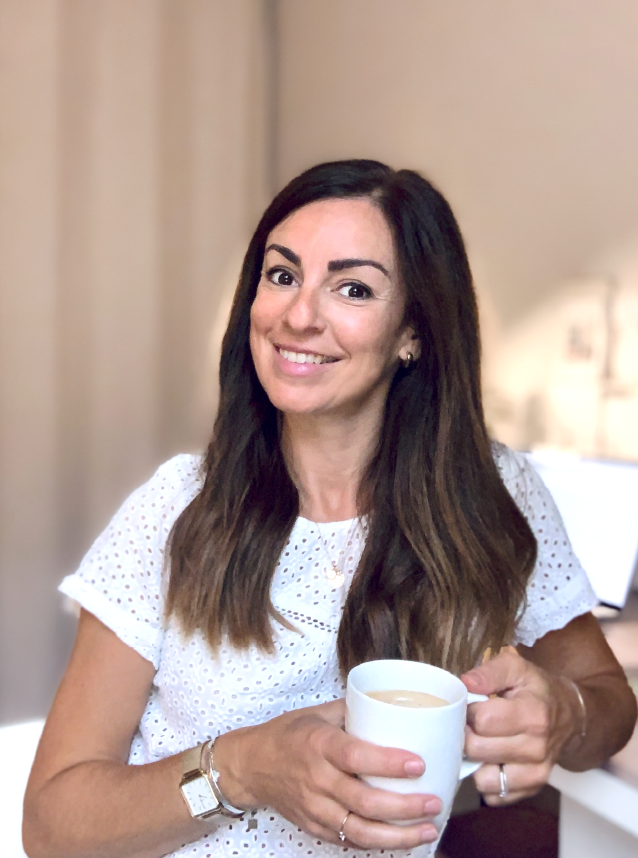 Marie Saquet-Gouville Graphiste et illustratrice Freelance assise à son bureau une tasse de café à la main et un sourire aux lèvres