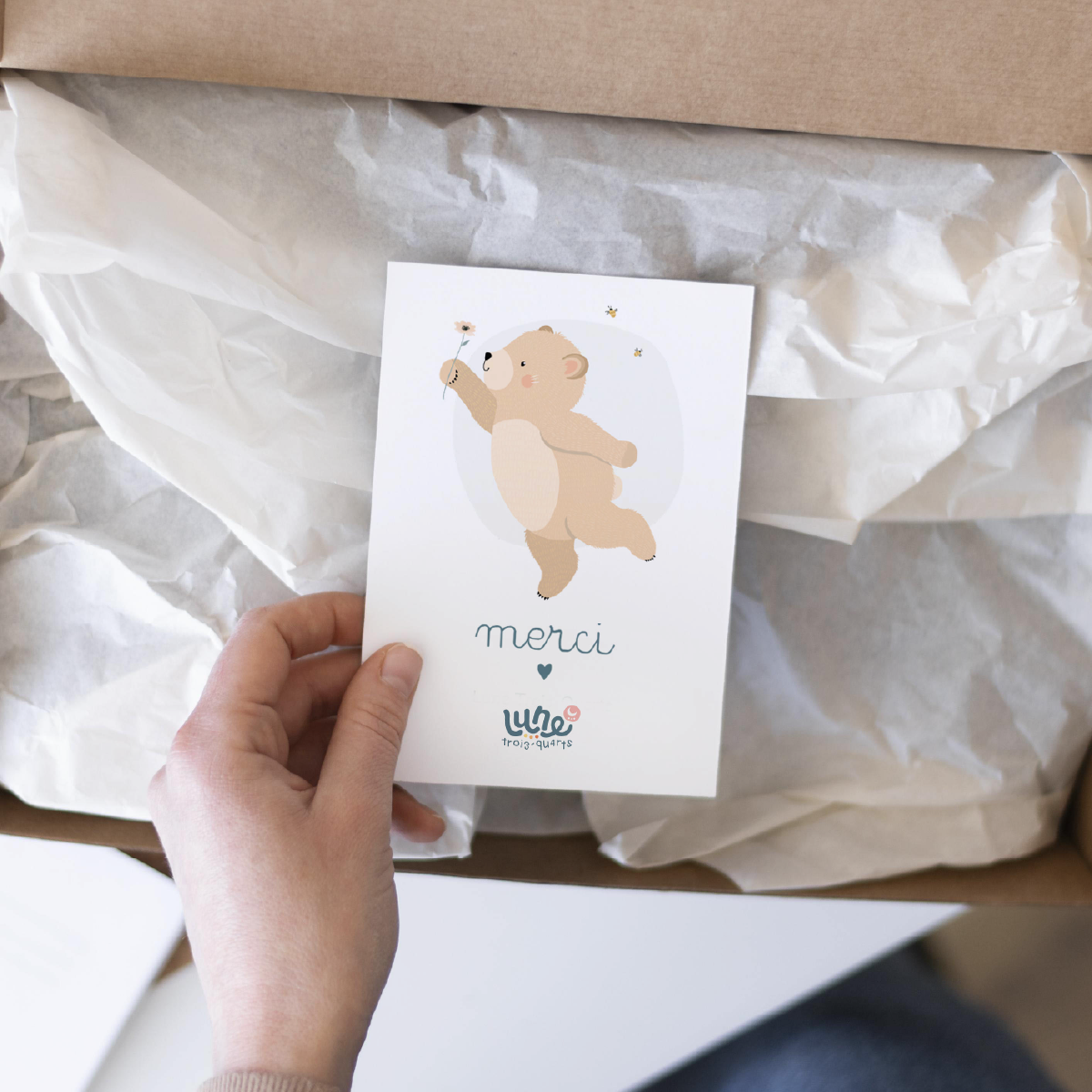 Carte illustrée avec ourson tenant un cœur et texte merci.